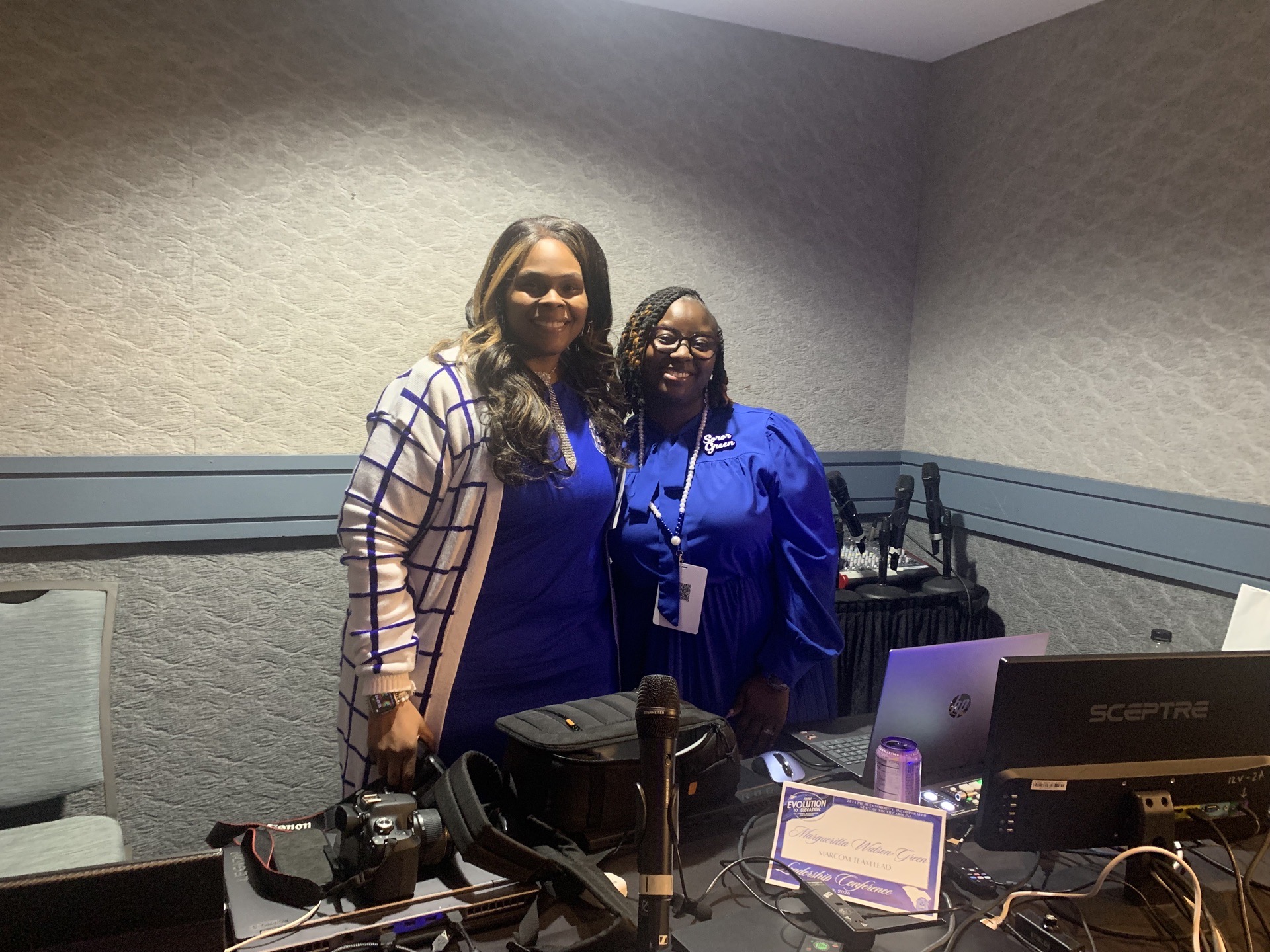 Latoya Jeeter smiling behind the media desk at a Zeta Phi Beta event